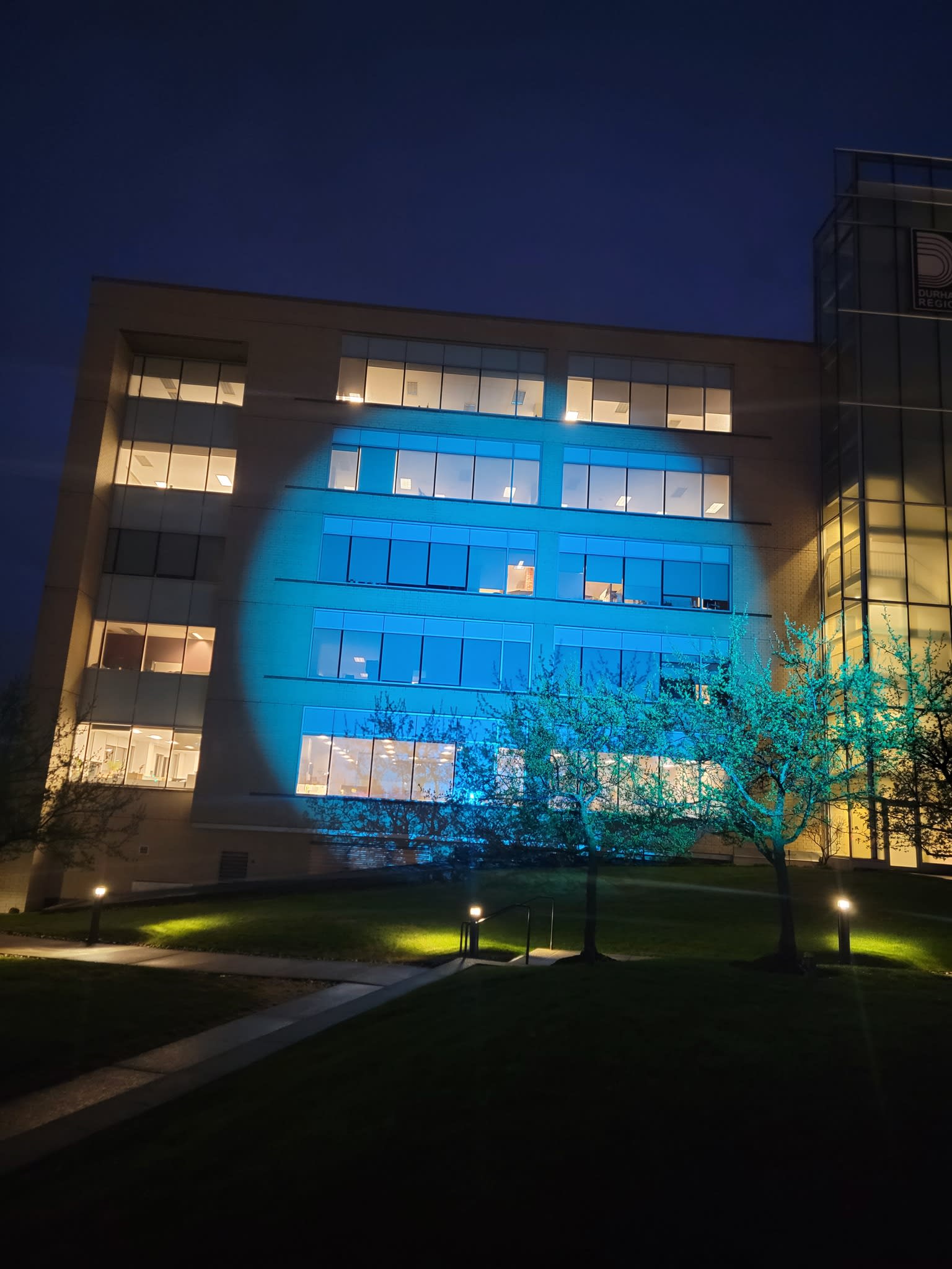Durham Regional HQ illuminated in blue for Community Living Month